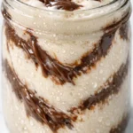 No-blender Nutella milkshake with creamy texture, topped with whipped cream and chocolate drizzle in a tall glass.