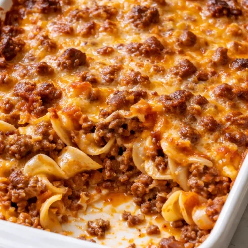Golden, bubbly ground beef casserole with melted cheese in a baking dish