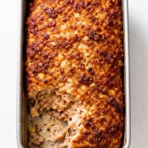 Mixing ground chicken with minced garlic, grated Parmesan, and fresh herbs for a juicy meatloaf mixture