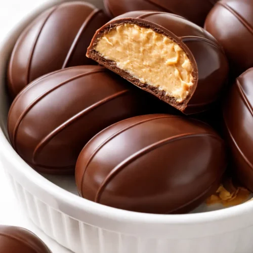 Homemade peanut butter Easter eggs with a dark chocolate shell that cracks cleanly, dusted with cocoa powder.