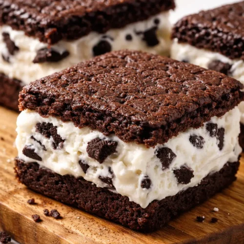Dark chocolate wafers sandwiching creamy vanilla ice cream with visible chocolate cookie crumbs, a decadent homemade Oreo ice cream sandwich.