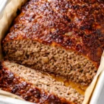 Moist Lipton onion soup meatloaf sliced on a plate with rich brown glaze and tender texture.