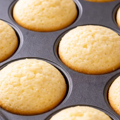 Mini lemon cakes with lavender glaze, tender crumb, bright floral flavor, garnished with fresh lavender sprigs and powdered sugar.