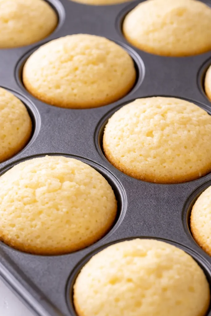 Mini lemon cakes with lavender glaze, tender crumb, bright floral flavor, garnished with fresh lavender sprigs and powdered sugar.