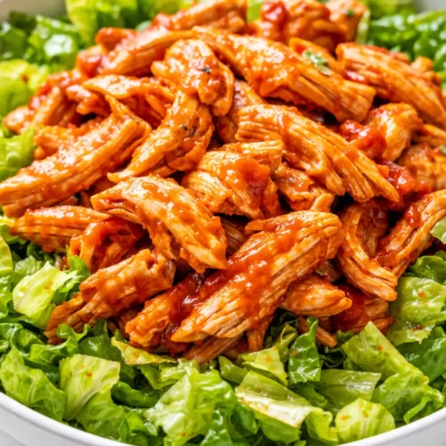 Creamy buffalo chicken salad with crunchy celery, carrots, and blue cheese crumbles in a white bowl, staying fresh and non-soggy.