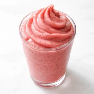 Thick, creamy strawberry Dole Whip blending into a smooth, pink frozen treat with a velvety texture.
