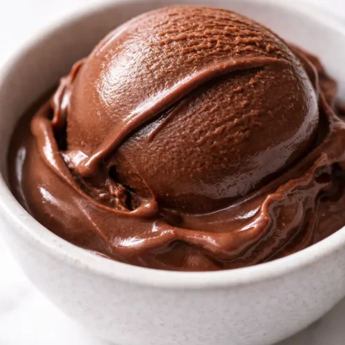 Smooth, dangerously dark chocolate gelato with a silky, slow-melt texture and glossy surface in a glass bowl.