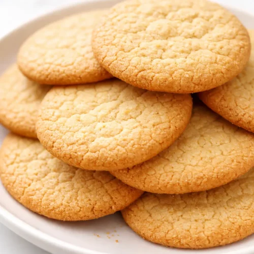 Golden brown vanilla wafers with a crisp snap and delicate crumb, stacked on a cooling rack.