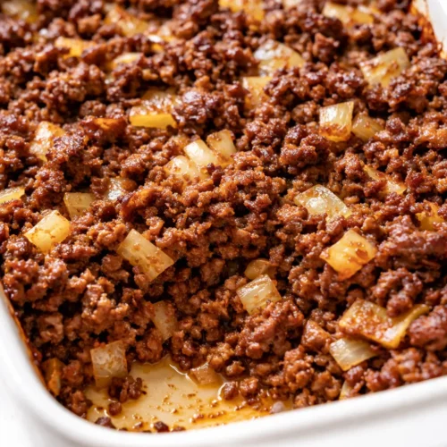 Hearty hobo casserole with ground beef, melted cheddar cheese, and tender vegetables, golden brown and bubbly in a baking dish.
