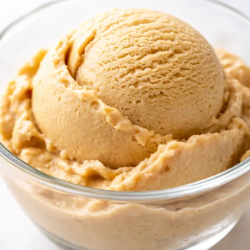 Scoop of creamy homemade coffee ice cream with rich brown color and smooth texture in a chilled glass bowl.