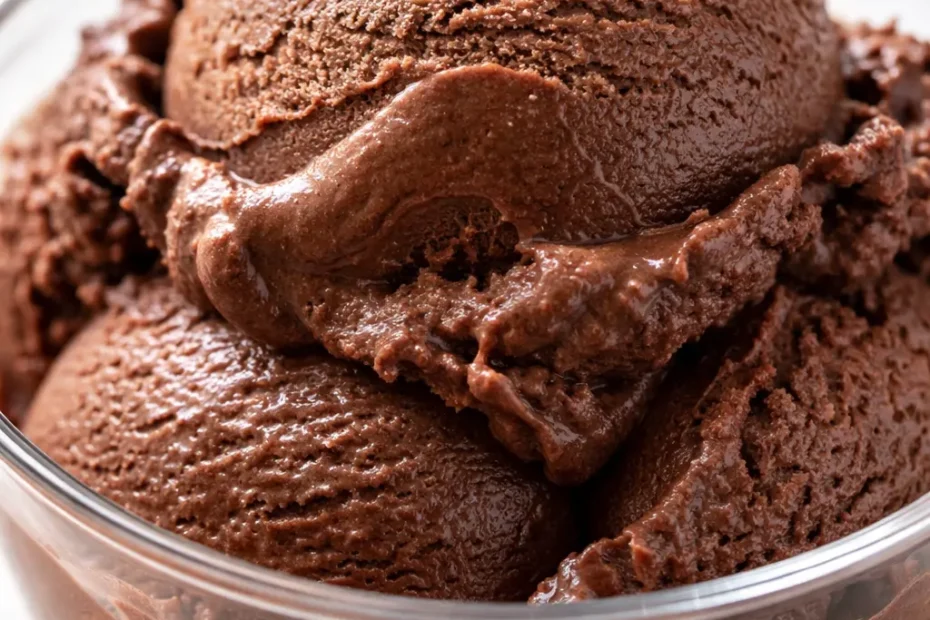 Silky homemade chocolate ice cream in a glass bowl, smooth and creamy texture, rich dark brown color.