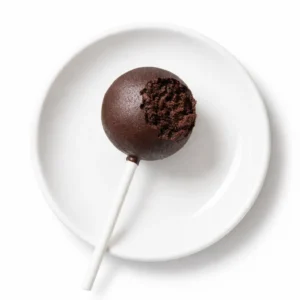 Homemade Starbucks cake pop batter being dipped in smooth white chocolate coating, with a crumbly texture visible.