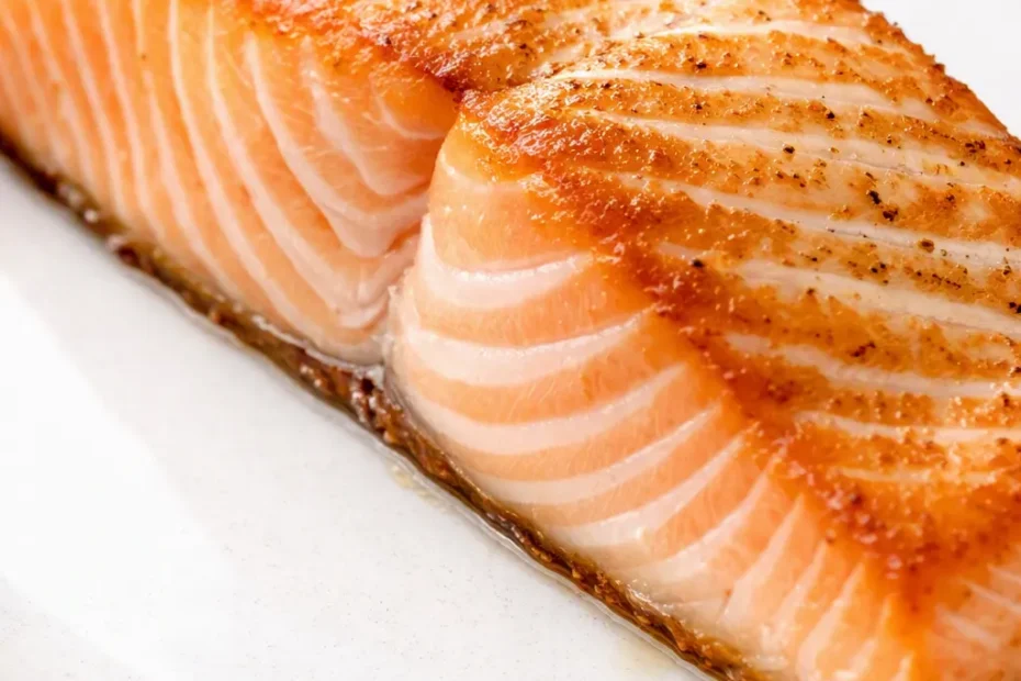 Air fryer salmon with golden-brown crust and tender, flaky pink flesh, garnished with lemon and fresh dill.