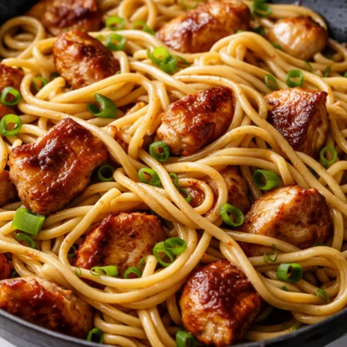 Savory chicken chow mein tossed with tender noodles, crunchy bell peppers, and carrots in a glossy soy glaze, topped with sesame seeds.